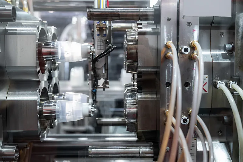 Injection molding plastic parts in process showing molten plastic being formed into precise custom components